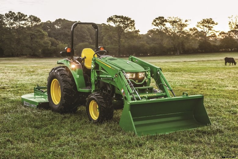 John Deere 4M Heavy Duty compact utility tractor with loader in a grassy field